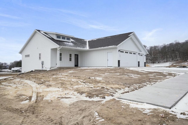 view of snowy exterior featuring a garage