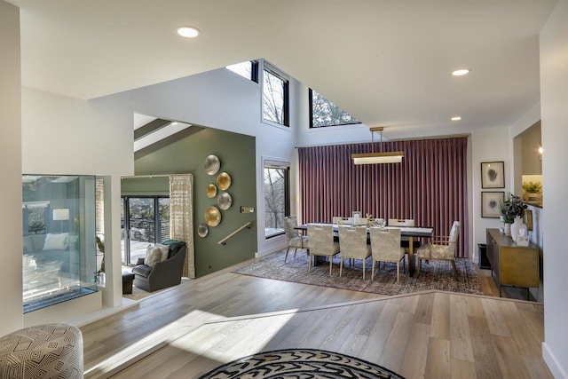 foyer entrance featuring hardwood / wood-style floors, high vaulted ceiling, and a wealth of natural light