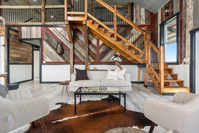 living room with hardwood / wood-style flooring and wood walls