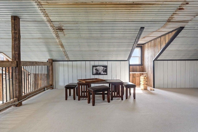 interior space featuring vaulted ceiling and wooden walls