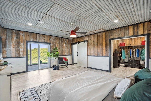 bedroom with access to exterior, ceiling fan, wood ceiling, a barn door, and light wood-type flooring