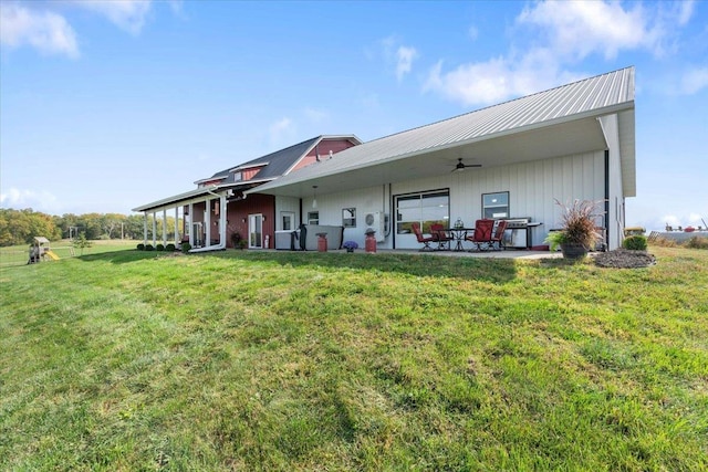 rear view of property with ceiling fan, a patio area, and a lawn