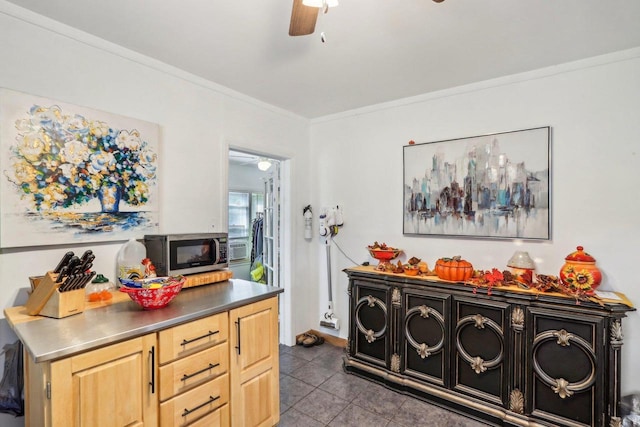 kitchen with ceiling fan, light brown cabinets, crown molding, and dark tile patterned floors