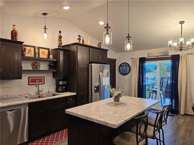 kitchen with stainless steel appliances, a center island, and decorative light fixtures