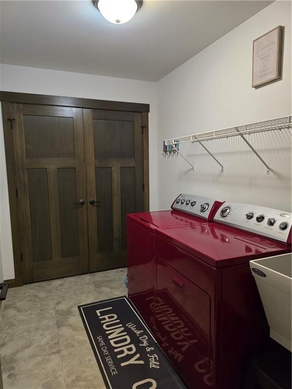 clothes washing area with washer and dryer and sink