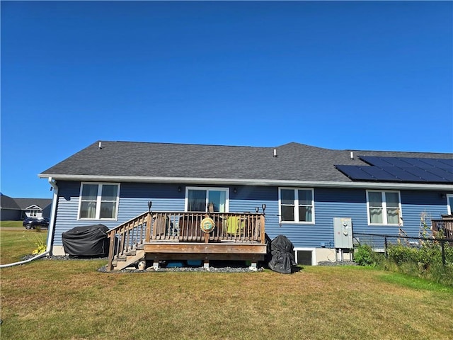 back of house with a wooden deck and a lawn