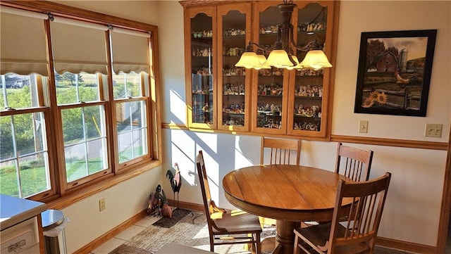 dining space with a wealth of natural light, light tile patterned floors, and a chandelier