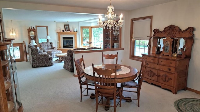 carpeted dining area featuring an inviting chandelier and a healthy amount of sunlight