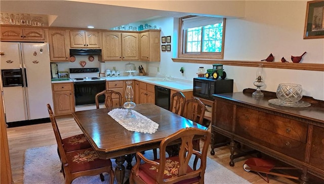 kitchen with sink, black appliances, and light wood-type flooring