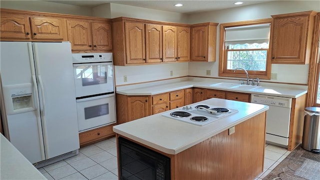 kitchen featuring a center island, white appliances, sink, and light tile patterned floors