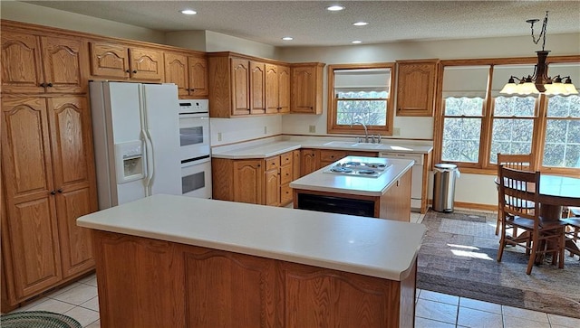 kitchen featuring a center island, white appliances, a textured ceiling, and a chandelier