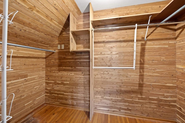 walk in closet with hardwood / wood-style flooring and vaulted ceiling