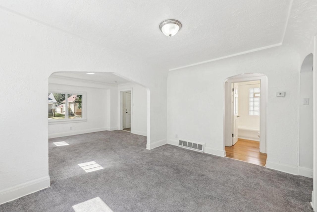 carpeted spare room featuring a textured ceiling