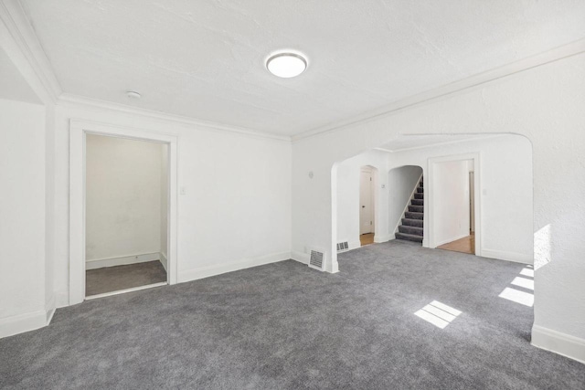 interior space with a textured ceiling, carpet flooring, and ornamental molding