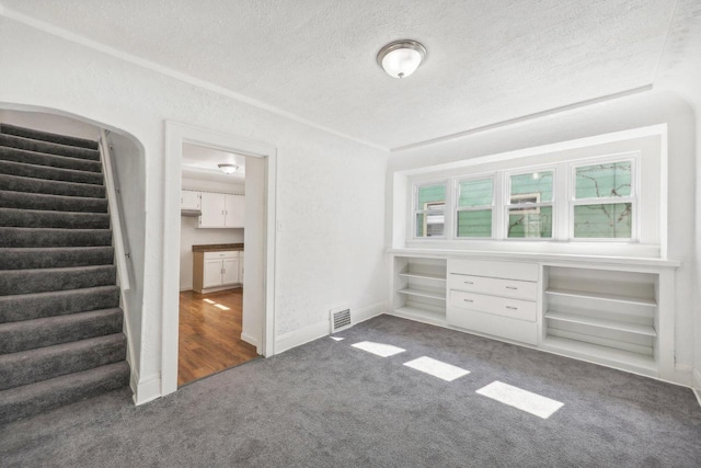 carpeted empty room with a textured ceiling