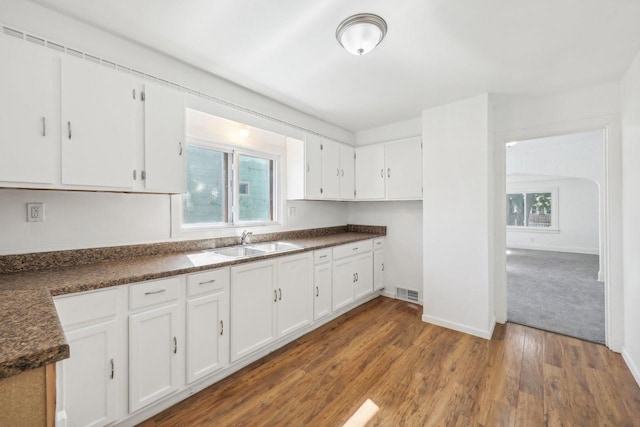 kitchen featuring sink, dark wood-type flooring, and white cabinets