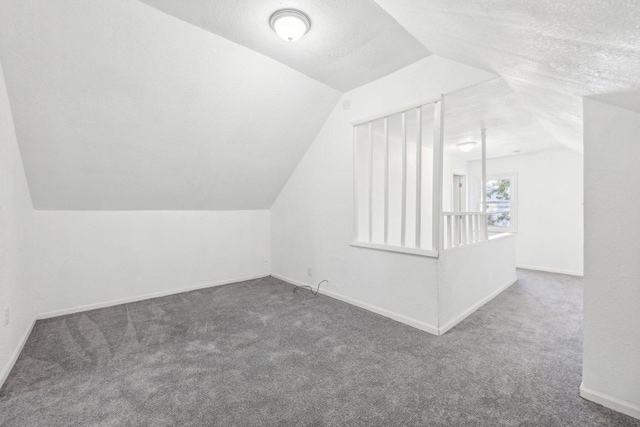 bonus room with carpet floors, a textured ceiling, and vaulted ceiling