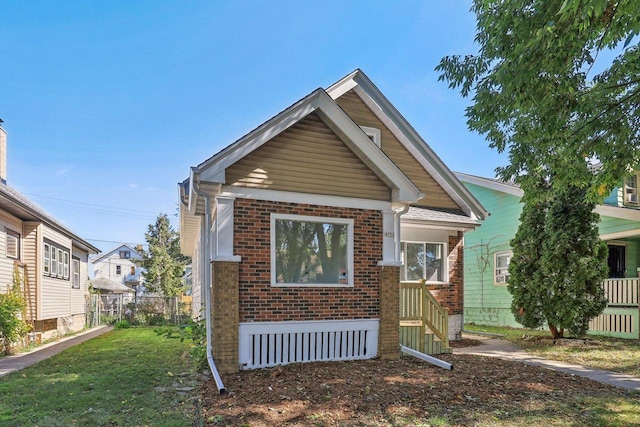 bungalow-style home with a front lawn