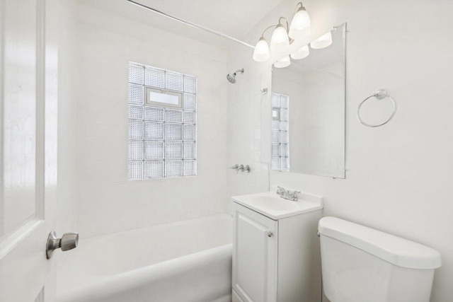 full bathroom with tiled shower / bath, vanity, and toilet