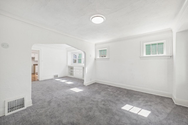 unfurnished room featuring carpet floors, a textured ceiling, and crown molding