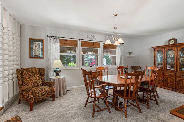 carpeted dining space with a chandelier