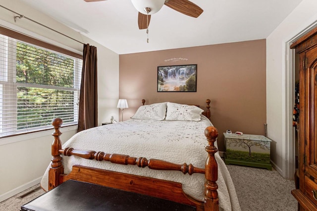 carpeted bedroom featuring multiple windows and ceiling fan