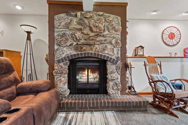 living area featuring carpet and a fireplace