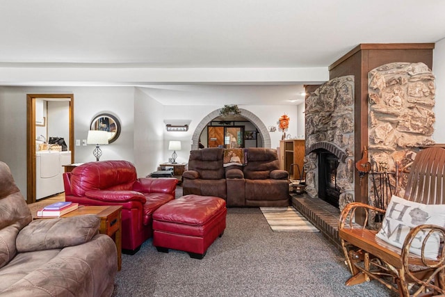 living room featuring washer / dryer, carpet floors, and a fireplace