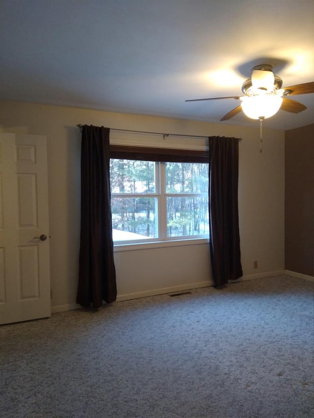 carpeted spare room featuring ceiling fan