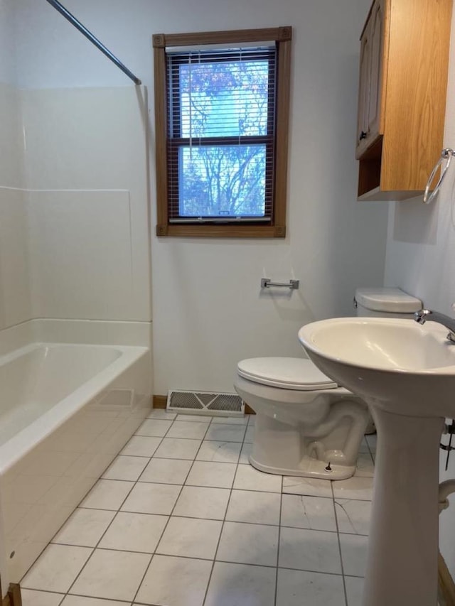 bathroom with shower / bath combination, tile patterned floors, and toilet