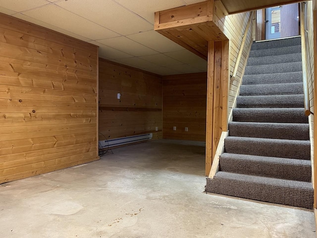 interior space with a baseboard radiator, concrete floors, and wood walls