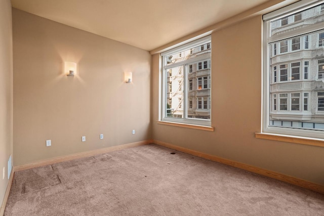 carpeted spare room featuring plenty of natural light