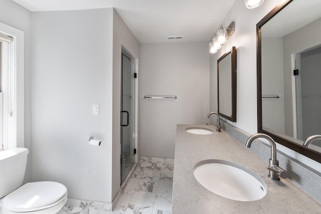 bathroom featuring a shower with shower door, vanity, and toilet