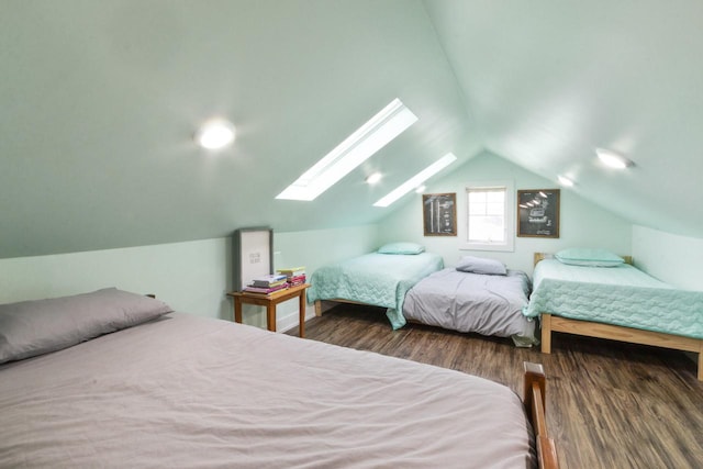 bedroom with lofted ceiling with skylight and dark hardwood / wood-style flooring