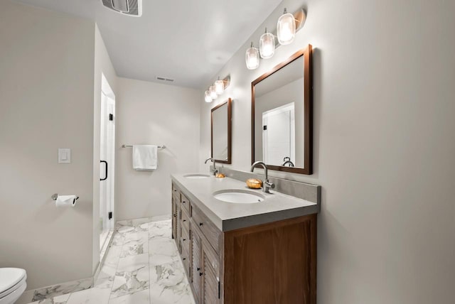 bathroom featuring vanity, toilet, and a shower with shower door