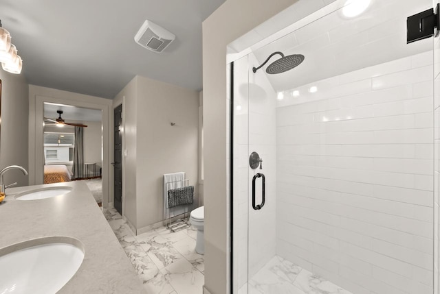 bathroom featuring ceiling fan, vanity, a shower with shower door, and toilet