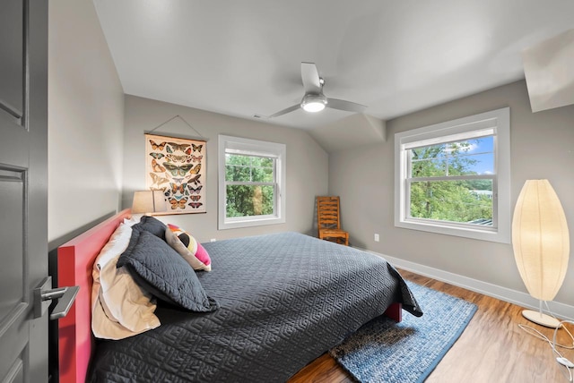 bedroom with ceiling fan, hardwood / wood-style flooring, lofted ceiling, and multiple windows