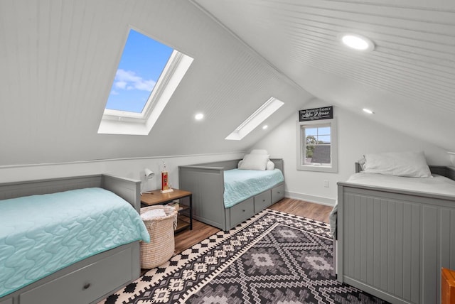 bedroom featuring lofted ceiling with skylight and dark hardwood / wood-style flooring