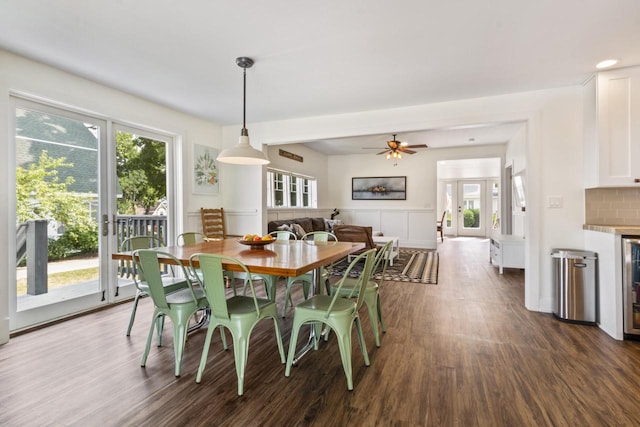 dining space with ceiling fan, wine cooler, plenty of natural light, and dark hardwood / wood-style flooring