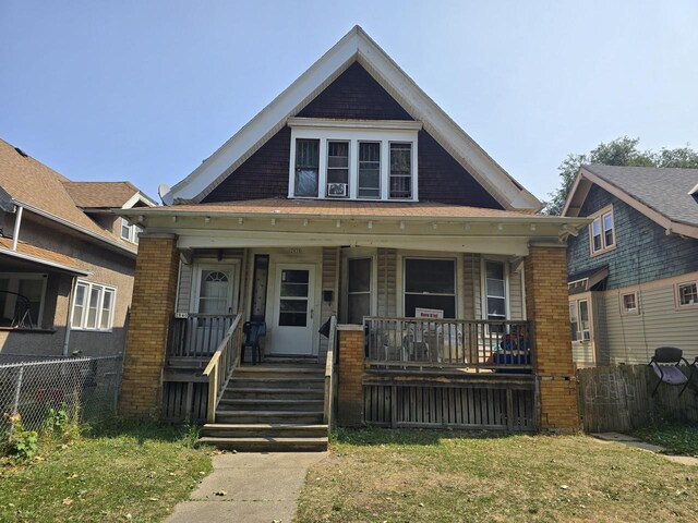 bungalow with a front lawn and covered porch