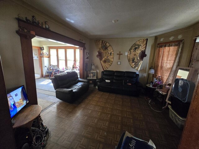 living room with a textured ceiling and dark parquet flooring