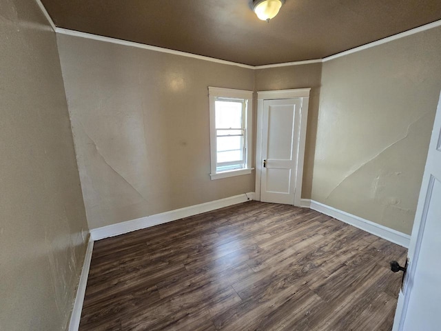 empty room featuring ornamental molding and dark hardwood / wood-style floors