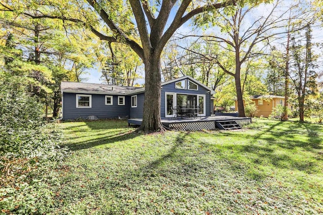 back of property with a deck and a lawn