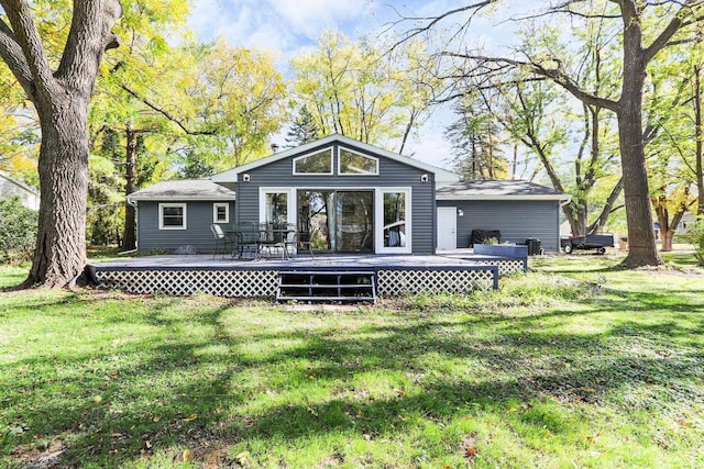 rear view of house with a yard and a wooden deck