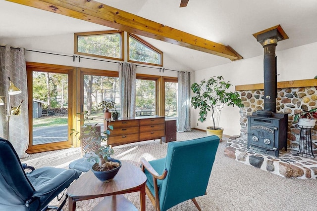 carpeted living room featuring beamed ceiling, a wood stove, and high vaulted ceiling