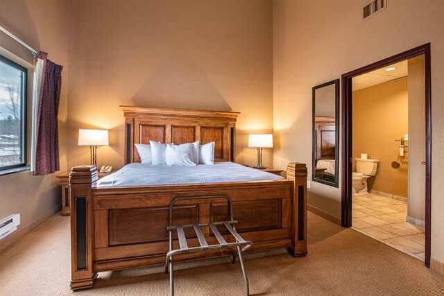 bedroom featuring light carpet and ensuite bathroom