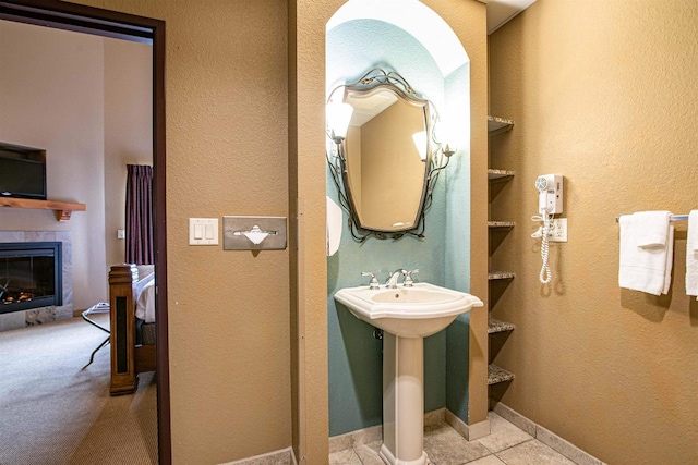 bathroom with a tiled fireplace and tile patterned floors