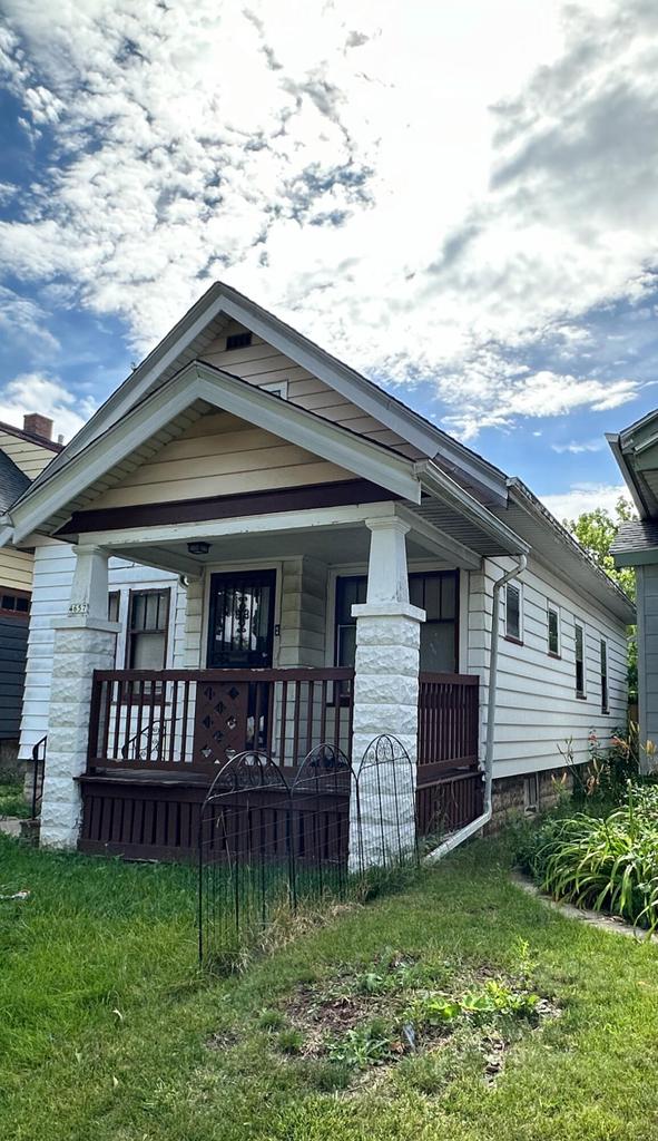 bungalow featuring a front lawn and a porch