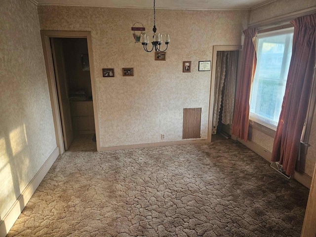 carpeted empty room featuring an inviting chandelier