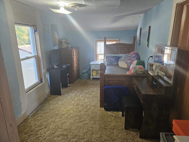 bedroom featuring ceiling fan, a textured ceiling, and carpet flooring